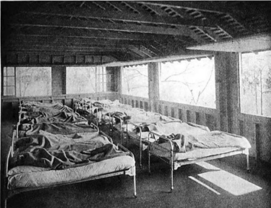 Tuberculosis preventorium porch with children resting in beds lined up in front of open windows